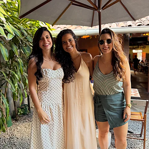 Amigas sorrindo na entrada da casinha do Pitaco